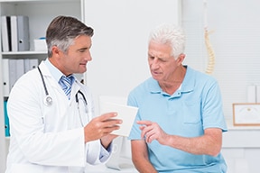 صورة لطبيب يراجع الأوراق مع مريض.