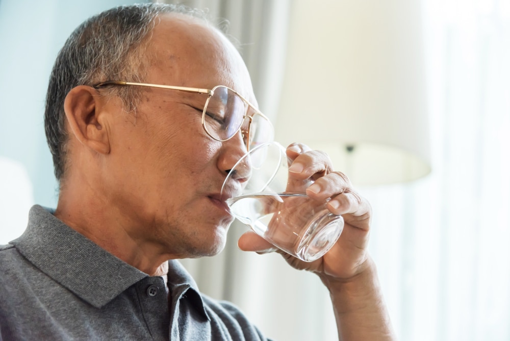 Man drinking a glass of water.