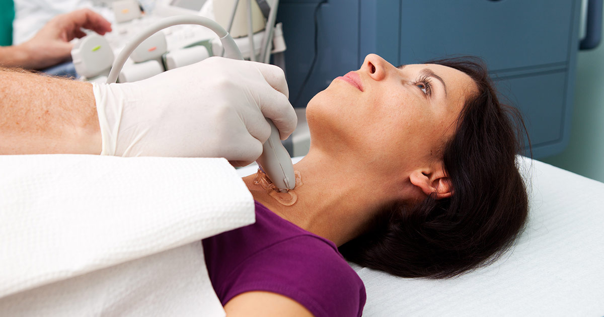 Una paciente haciéndose una ecografía de la tiroides. Le pasan un transductor sobre el cuello para la prueba.