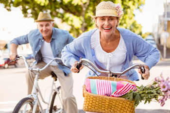 Smiling man and woman riding bikes.