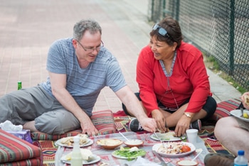 Man and woman having picnic lunch outside