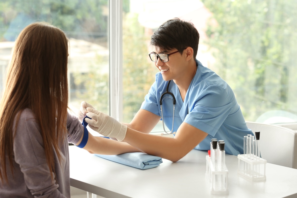 Health care professional preparing to take a blood sample from a patient.