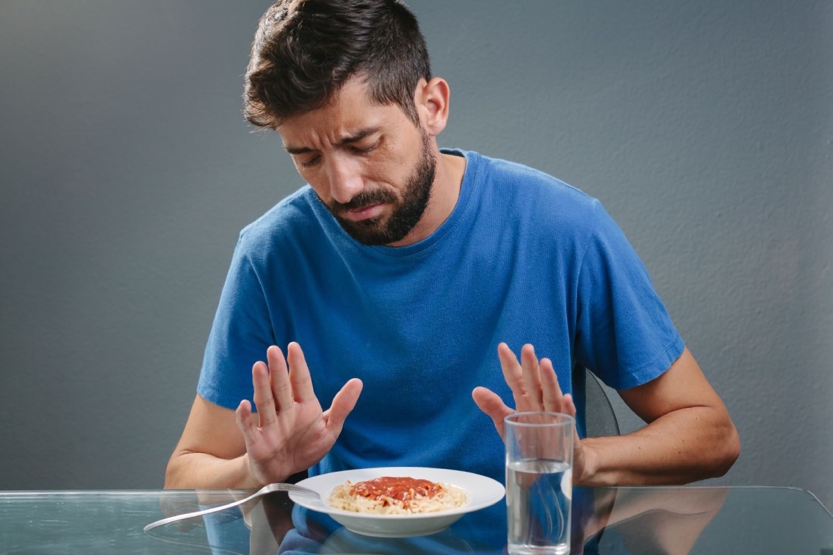 Hombre rechazando un plato de comida.