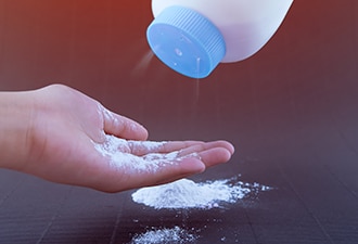 White powder being sprinkled from a bottle onto a hand.