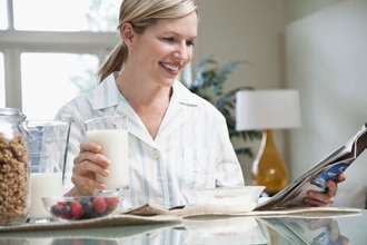 Woman drinking glass of milk at table