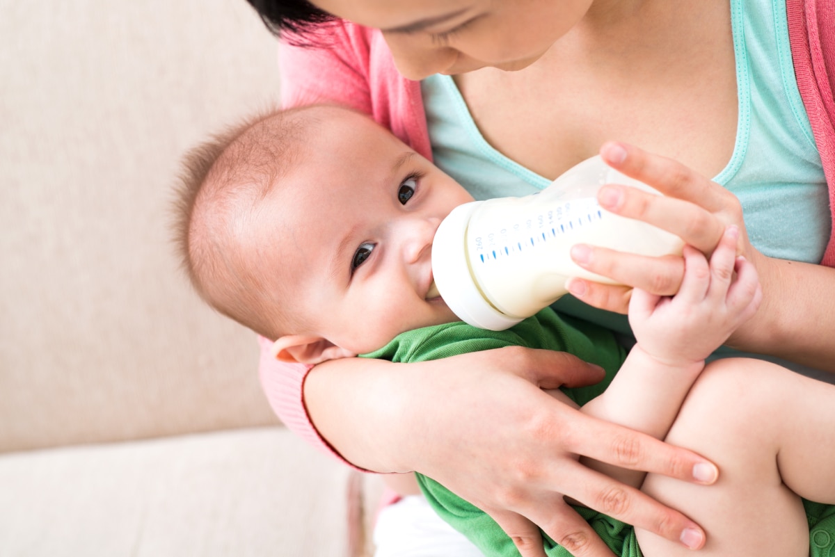 Mother feeding a bottle to an infant.