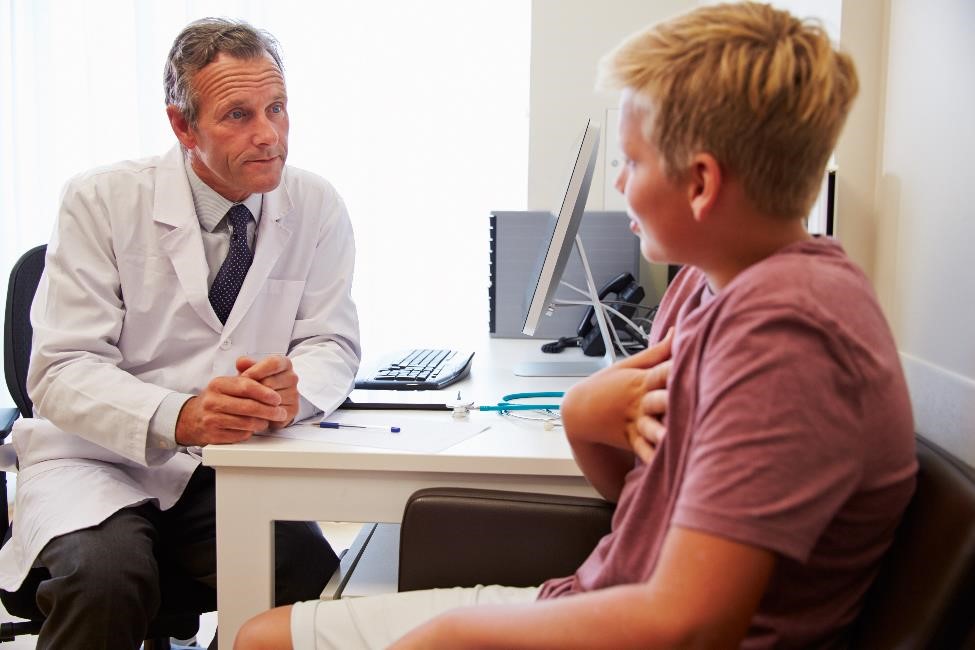 Doctor talking with a teenage patient.