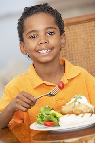 Um menino a comer um jantar saudável.