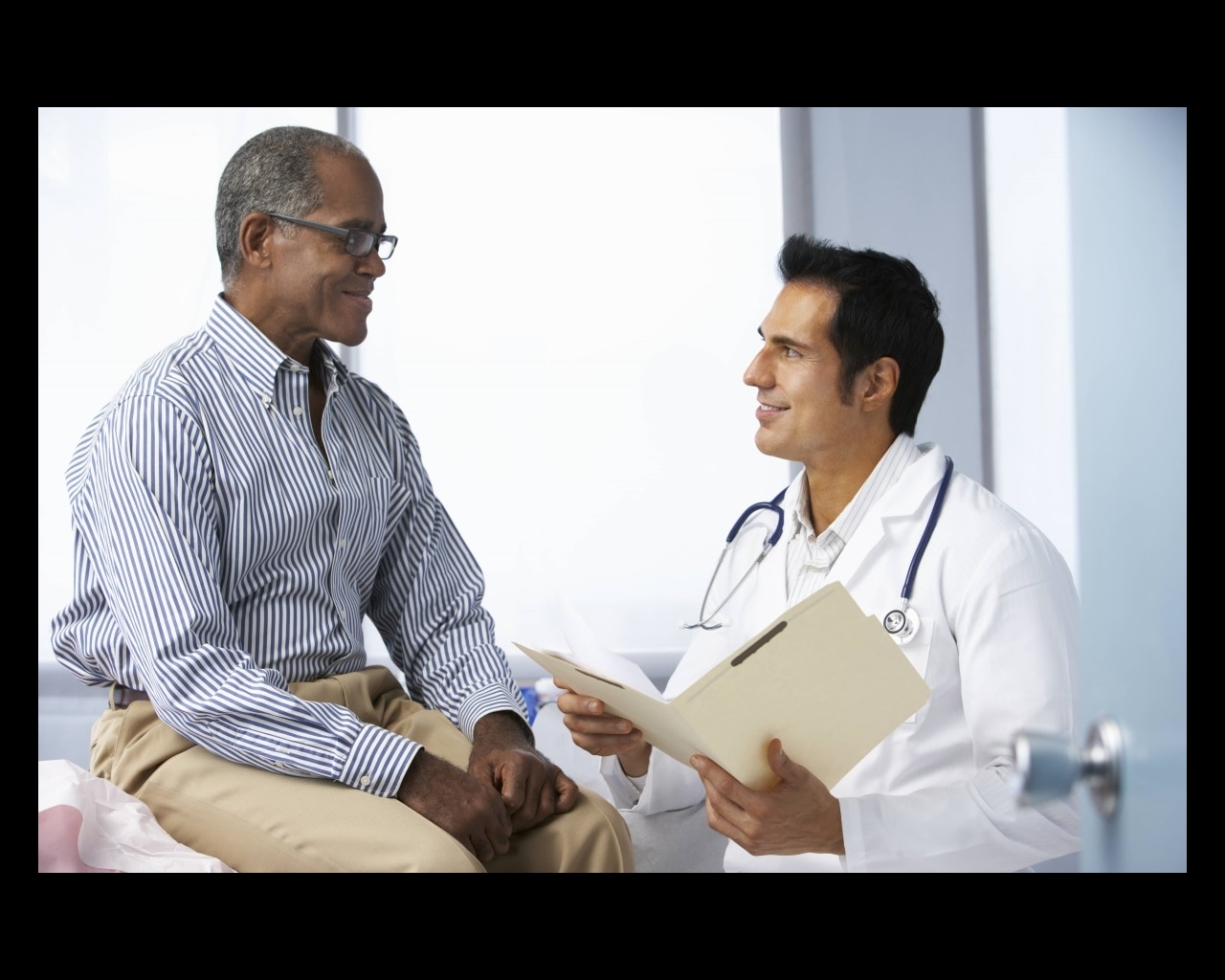 Patient talking with a doctor in a doctor’s office.