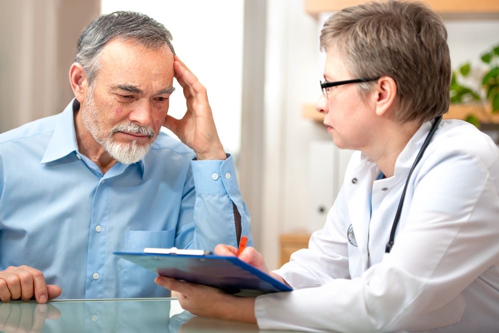 Doctor talking with an older, male patient.