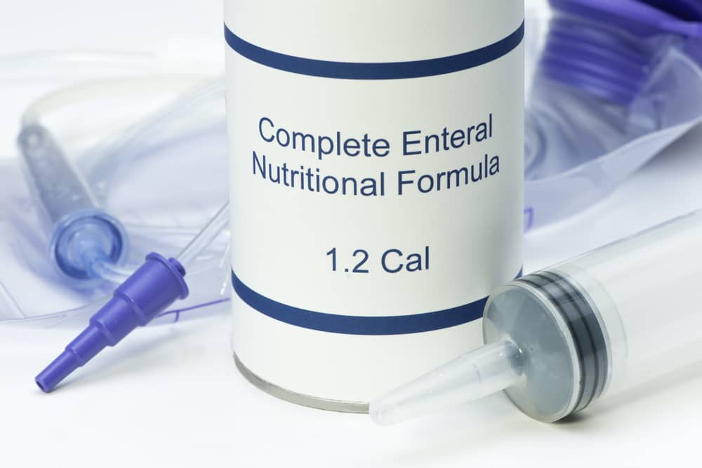 Medical supplies for nutrition support, including a can of complete enteral nutritional formula