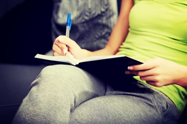 A woman making notes in a food diary.