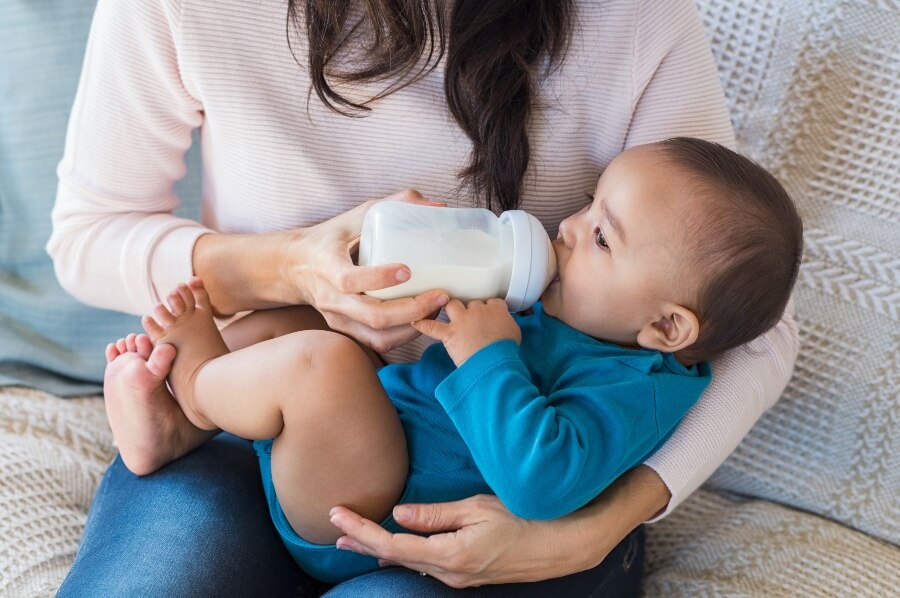 Madre alimentando al bebé con un biberón.