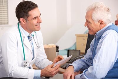 Un médico hablando con un paciente en su consultorio.