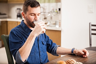 Un hombre tomando un vaso de leche.