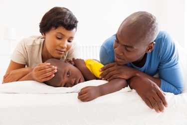 A mother and father with sick child.