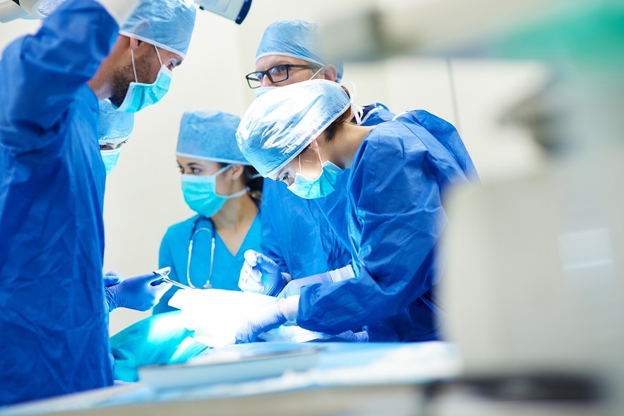 Group of Surgeons performing surgery in an operating room.