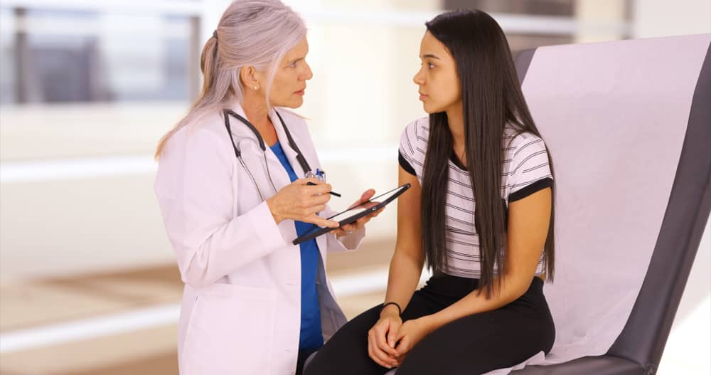 Doctor talking with a teenage patient.