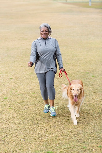 Woman walking a dog outdoors