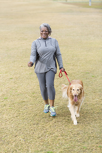 Woman walking a dog outdoors