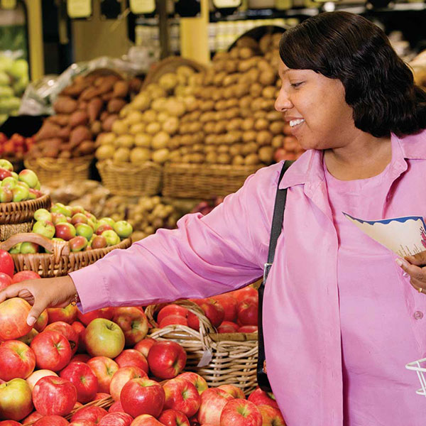 Mujer comprando frutas y verduras.