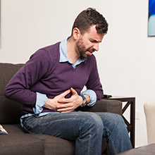 man touching his belly and having a stomach ache at home