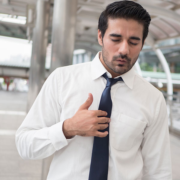 A man presses on his chest in pain.