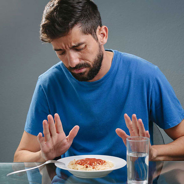 Hombre rechazando un plato de comida.
