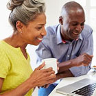 A woman and a man viewing a laptop