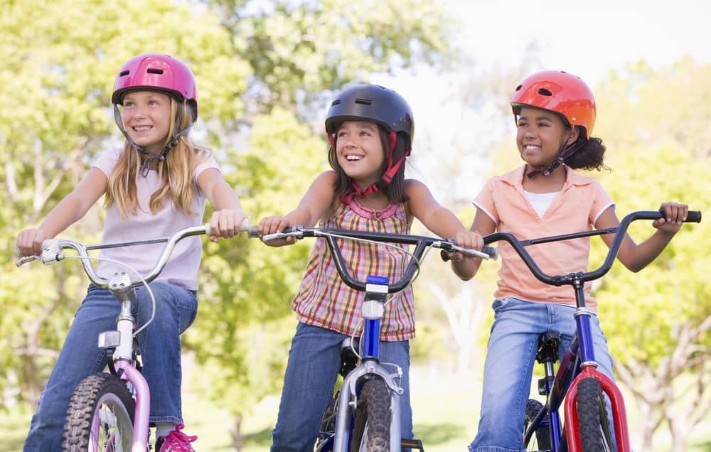 Three young girls on bicycles.
