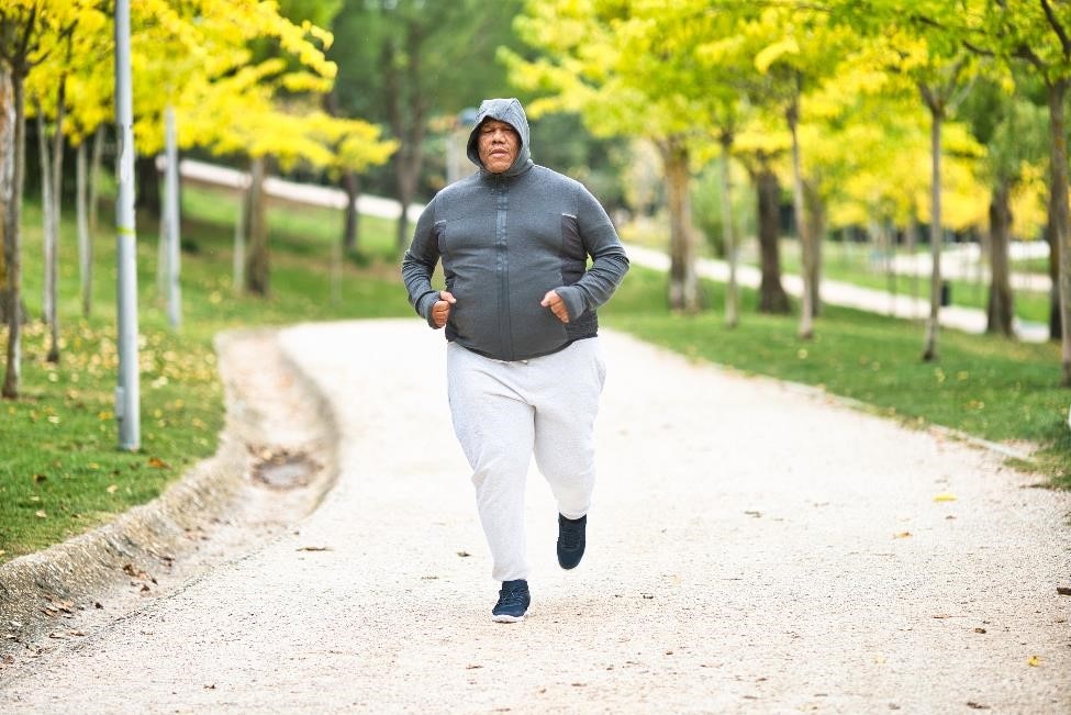 Overweight man jogging in the park.