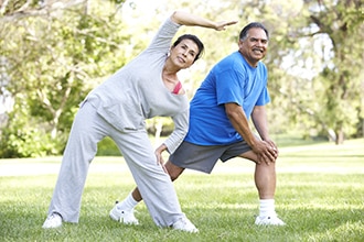 A man and woman exercising in a park.