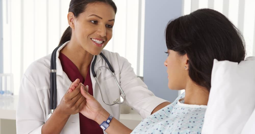 A health professional examines a patient in a doctor's office.