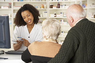 Una pareja hablando con un farmacéutico.