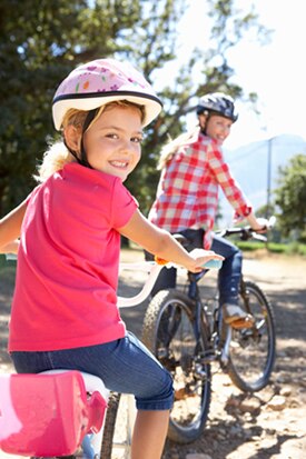 Una mamá y su hija pequeña andando en bicicleta.