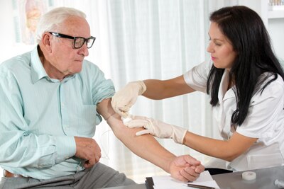 Una enfermera tomando una muestra de sangre a un señor mayor.