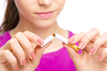 La mujer que rompe un cigarrillo por la mitad