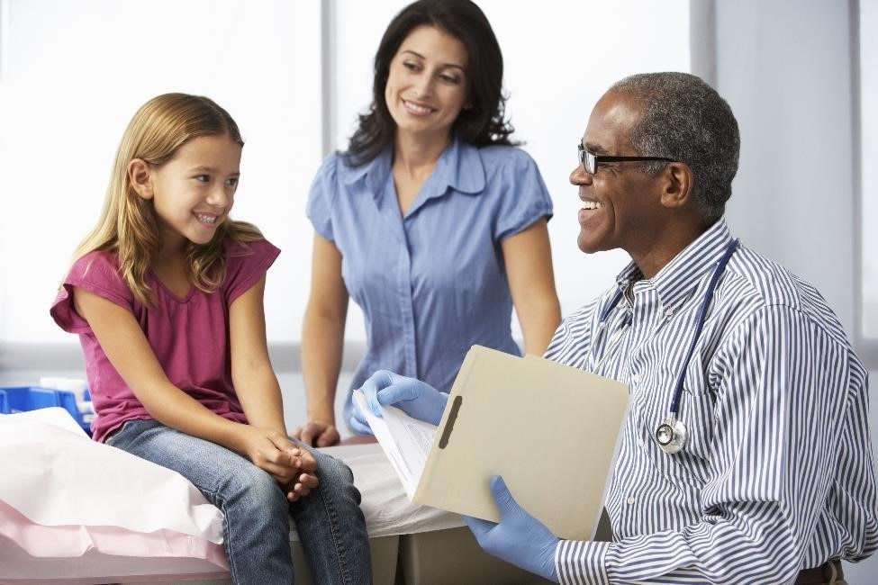 Doctor talking with a young girl patient and her mother
