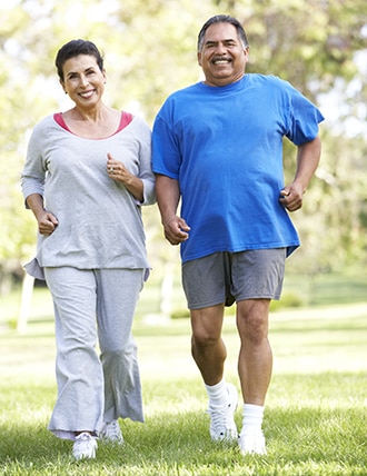 Una pareja con sobrepeso caminando al aire libre.