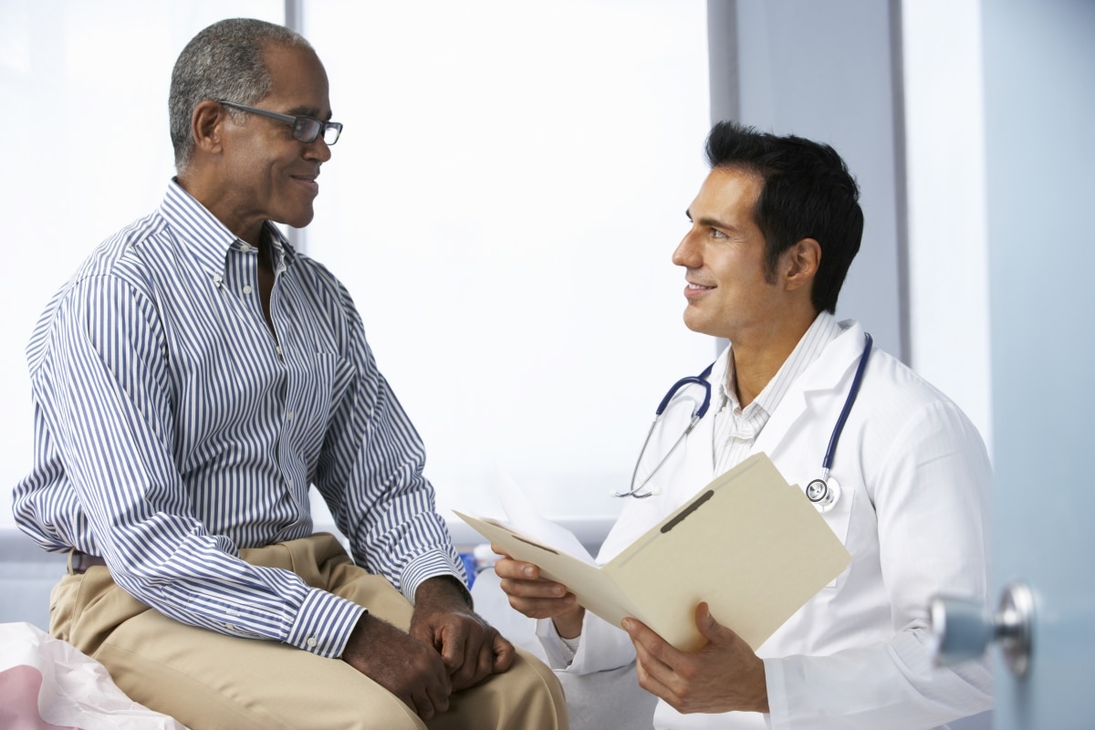 Un hombre habla con un médico en un consultorio.