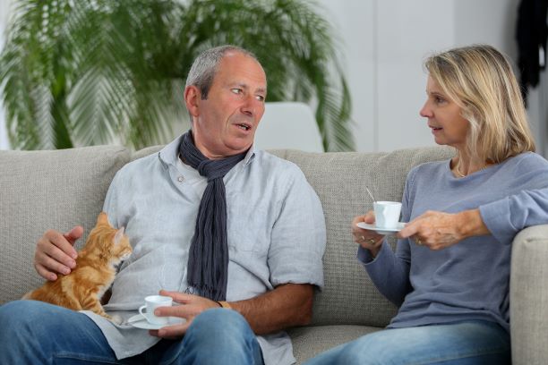 Man and woman drinking tea on the couch.