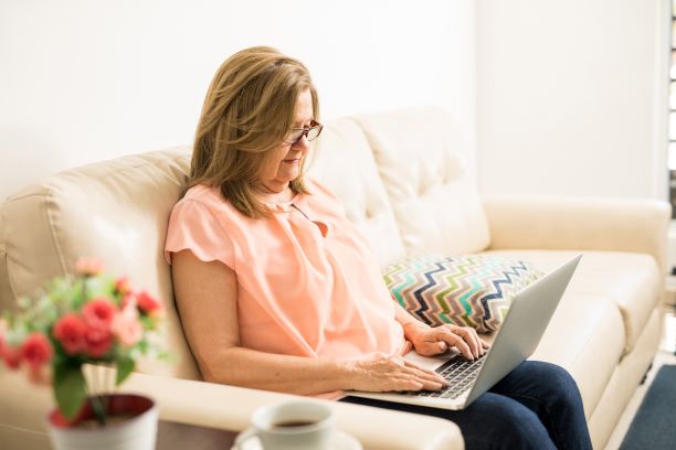 Woman using her laptop on her couch.