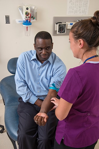 A health care provider preparing to draw blood from a patient.