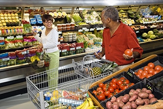 Pareja en el supermercado escogiendo productos.