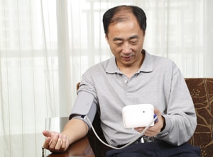 A photo of a man checking his blood pressure.