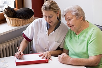 Health care provider shares information with a woman in her home.