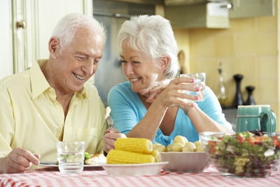 A photo of a man and a woman sitting at a table and eating a healthy meal