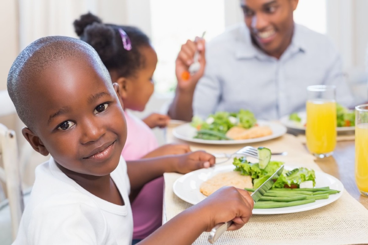 Young child eating dinner with family