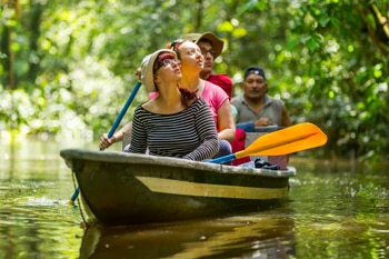Unos turistas en un barco de remos en un río.