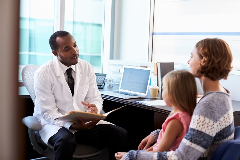 Doctor talking with a mother and her young daughter.